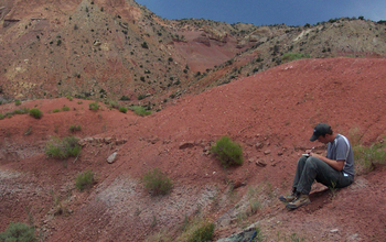 Scientist Randall Irmis taking notes at research site